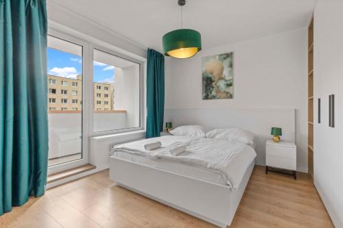 - une chambre blanche avec un lit et une grande fenêtre dans l'établissement LAM Green w AC & balcony, à Bratislava