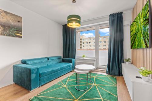 a living room with a blue couch and a window at LAM Green - AC -BALCONY in Bratislava