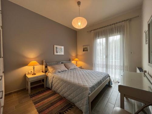 a bedroom with a bed and two lamps and a window at Easy Living 1 & 2 in Kos Town
