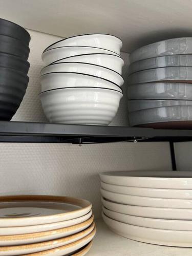 a group of plates and bowls on a shelf at Le Gite de la Poterne, maison en bordure du Serein in Chablis