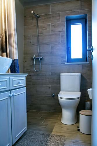 a bathroom with a toilet and a window and a shower at Easy Living 1 & 2 in Kos Town