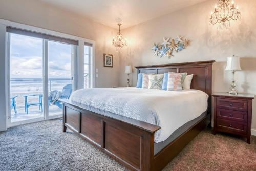 a bedroom with a bed and a view of the ocean at Seascape Rockaway - Meredith Lodging in Rockaway Beach