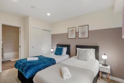 ベッドフォードにあるBright 2BR in Bedford, Parking, Free WiFi, Gym & Cinema roomのベッドルーム1室(青と白のベッド2台付)