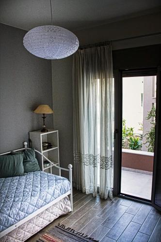 a bedroom with a bed and a sliding glass door at Easy Living 1 & 2 in Kos Town