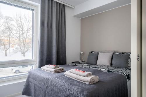 a bedroom with a bed with towels on it at Apartment near the train station, free parking &Netflix in Kuopio