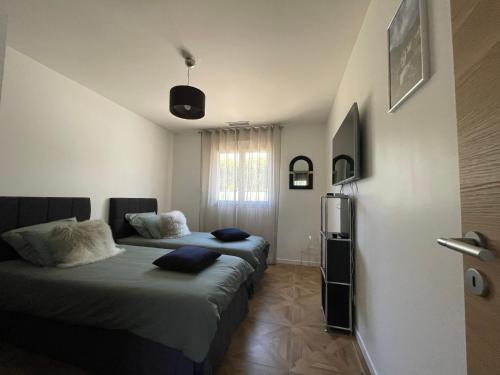 1 Schlafzimmer mit 2 Betten und einem Fenster in der Unterkunft Magnifique villa récente entre mer et montagne située entre Ajaccio et Porticcio in Cauro