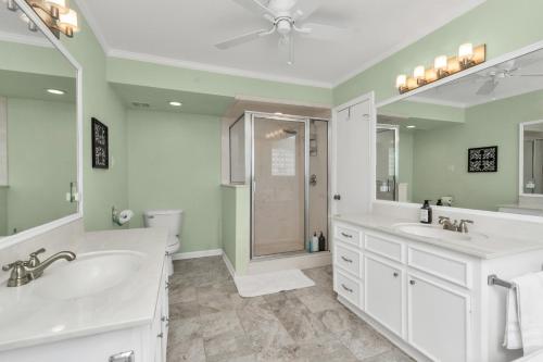 a bathroom with two sinks and a shower at Beauty on the Water! Lake House near the beaches! in Galveston