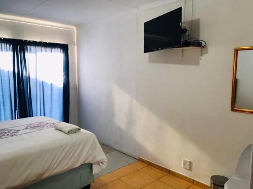 Schlafzimmer mit einem Bett und einem Flachbild-TV in der Unterkunft DAX BnB 