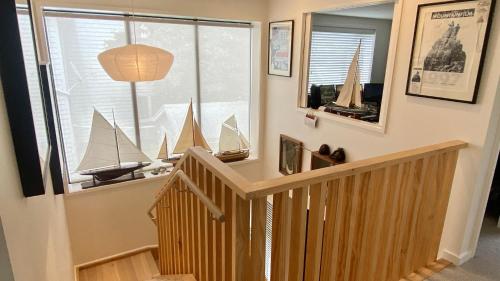 una habitación con una escalera con un barco modelo en la pared en Stylish Townhouse, en Auckland