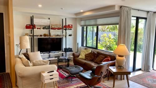 uma sala de estar com um sofá e uma televisão em Stylish Townhouse em Auckland