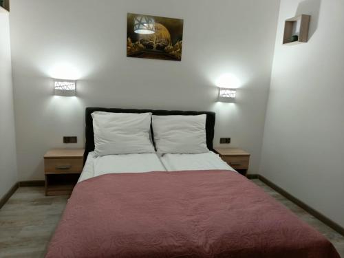 Ce lit se trouve dans un dortoir doté de 2 tables de nuit et de 2 lumières. dans l'établissement Apartament Maria, à Sianożęty