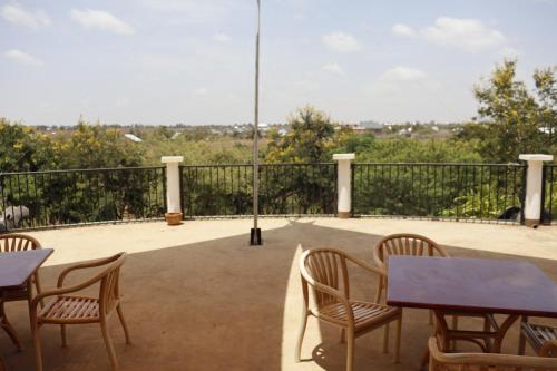 a patio with tables and chairs on a balcony at Themi View in Arusha