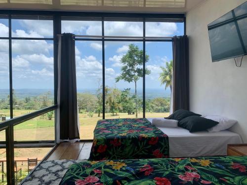 a bedroom with two beds and a large window at Villa Aura in Fortuna