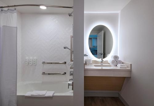 Baño blanco con lavabo y espejo en TownePlace Suites by Marriott Brentwood, en Brentwood