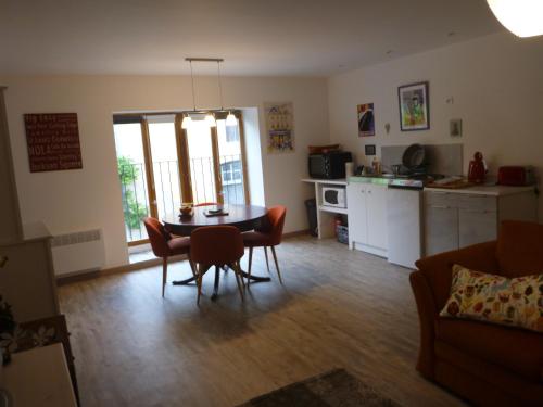 un salon avec une table et des chaises et une cuisine dans l'établissement Montagne Noire Apartment Saissac, à Saissac