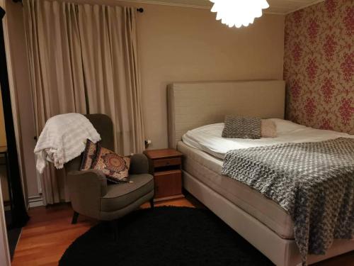 1 dormitorio con 1 cama, 1 silla y 1 lámpara de araña en OWN ROOM WITH BIG BED IN A BIG HOUSE! en Luleå