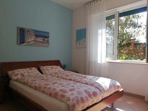 a bedroom with a bed and a window at LA CASA DI MARZIA in Bardolino