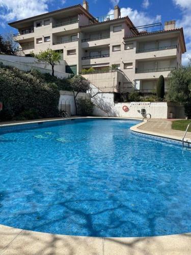 uma grande piscina azul em frente a um edifício em Apartamento con Piscina en Llança em Llançà