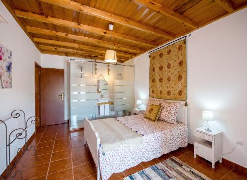 a bedroom with a bed and a wooden ceiling at Vale do Grou Natura in Óbidos