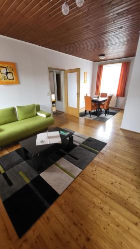 a living room with a green couch and a table at Gasthof Moser in Fohnsdorf