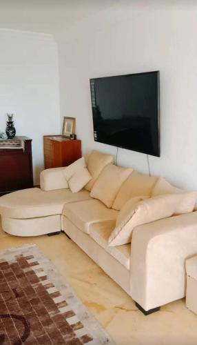 salon z białą kanapą i telewizorem z płaskim ekranem w obiekcie الاسكندرية w Aleksandrii