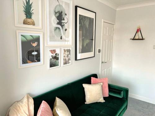 a living room with a green couch and pictures on the wall at Quirky, Family Home in Glasgow in Cardonald