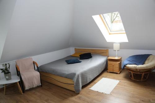 sypialnia z łóżkiem, krzesłem i oknem w obiekcie Willa Vita - Apartment z kominkiem i dużym tarasem, Sauna, Jacuzzi, Altana z Grill, z możliwością wynajmu dotakowych pokoi - Schönes Appartement mit Kamin und großer Terrasse, Sauna, Jacuzzi, Pavilion mit Grill und der Option zusätzliche Zimmer zu mieten w Stegnie