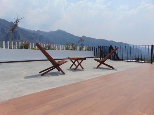 two wooden benches sitting on top of a patio at Casa Naâmja in Tepoztlán