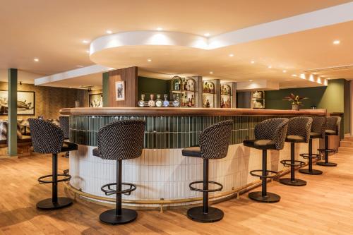 a bar with black stools in a room at Faern Crans-Montana Valaisia in Crans-Montana