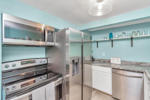 a kitchen with stainless steel appliances and a microwave at Galveston Studio - Sleeps 7 - Minutes to Beach !! in Galveston