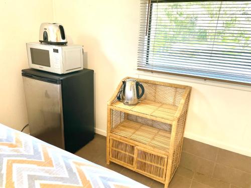 a room with a microwave and a table with a microwave at Waiheke Onetangi Close to Beach in Onetangi