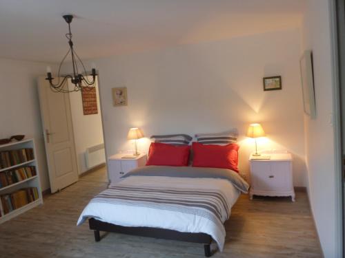 - une chambre avec un lit doté d'oreillers rouges et de 2 lampes dans l'établissement Montagne Noire Apartment Saissac, à Saissac