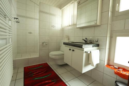 a white bathroom with a sink and a toilet at Dorf-Schmiede - Bed und Breakfast in Müllheim