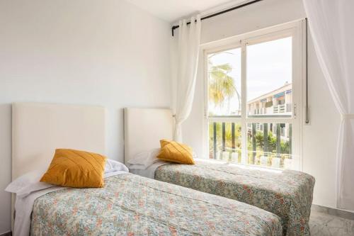 2 camas en una habitación con ventana en Lorcrimar 3 Apto cerca de la playa con piscina, en Marbella