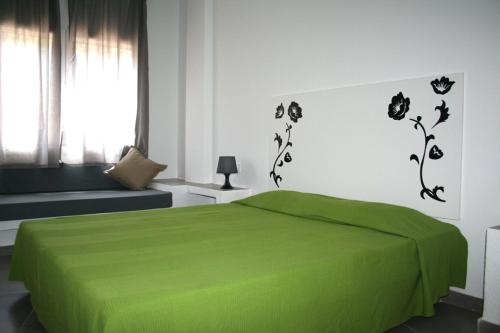 ロザスにあるApartaments La Rieraのベッドルーム(緑のベッド1台、窓付)