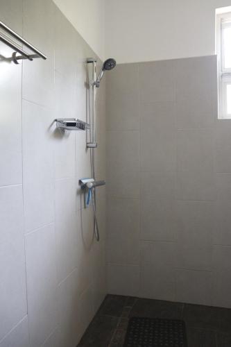 a shower in a bathroom with a tile wall at Themi View in Arusha