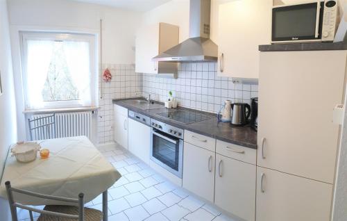 聖哥亞豪森的住宿－Ferienwohnung Späth，厨房配有白色橱柜、桌子和微波炉