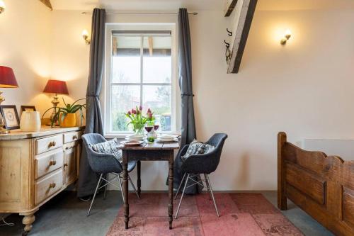 a room with a table and chairs and a window at The Stables in Kampen