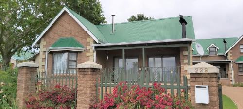 una casa con tetto verde e recinzione di Clarens Mountain Sage Cottage a Clarens