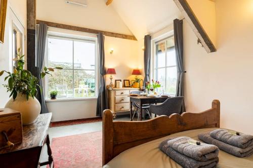 een slaapkamer met een bed, een bureau en een raam bij The Stables in Kampen