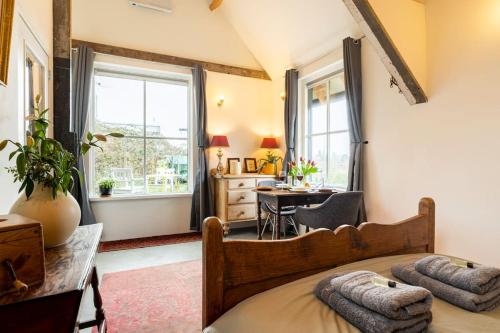 a bedroom with a bed and a desk and a window at The Stables in Kampen