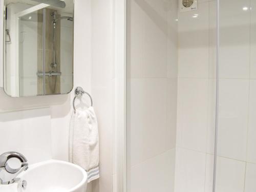 a white bathroom with a sink and a mirror at Jims Place - Uk42085 in Sedbergh