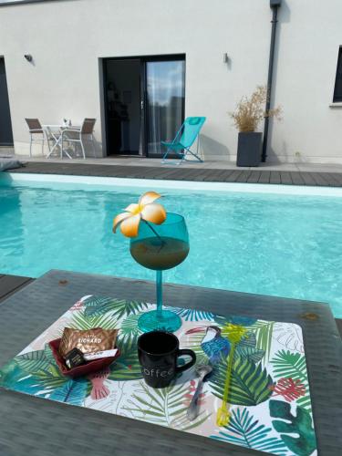 a table with a drink on it next to a swimming pool at La casita de Vanessa in Changé