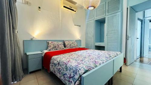 a small bedroom with a bed with a red blanket at 3 bedrooms appartement with sea view balcony and wifi at Trou aux Biches 1 km away from the slopes in Trou aux Biches