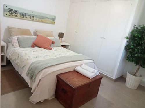 a bedroom with a bed with pillows and a plant at Dormir entre limones, Casa de invitados en vivienda familiar in Dos Hermanas