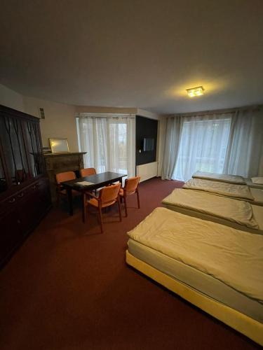 una camera d'albergo con due letti e un tavolo con sedie di WILLA KASKADA Łomiańska 33 Warszawa a Varsavia