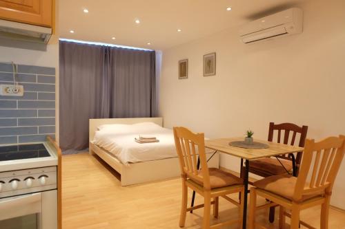 uma cozinha e sala de jantar com uma mesa e uma cama em Bivalvia Apartments em Koper