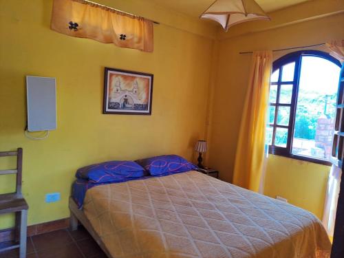a bedroom with a bed in a room with a window at Carnavalito Hostel Tilcara in Tilcara