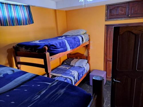 a room with two bunk beds in a room at Carnavalito Hostel Tilcara in Tilcara