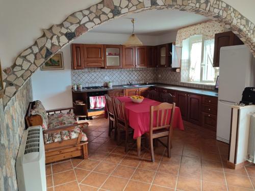 a kitchen with a table with a pink table cloth at Appartamento stile rustico in collina 